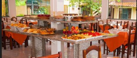Montaje de bufé con diferentes alimentos y una vista tropical.