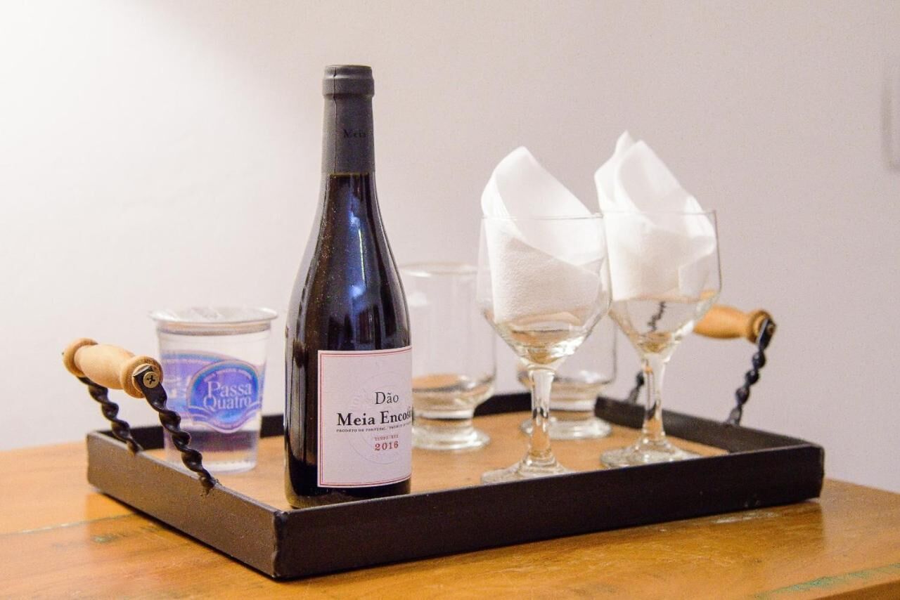 A bottle of wine, two glasses, and a water bottle on a tray.