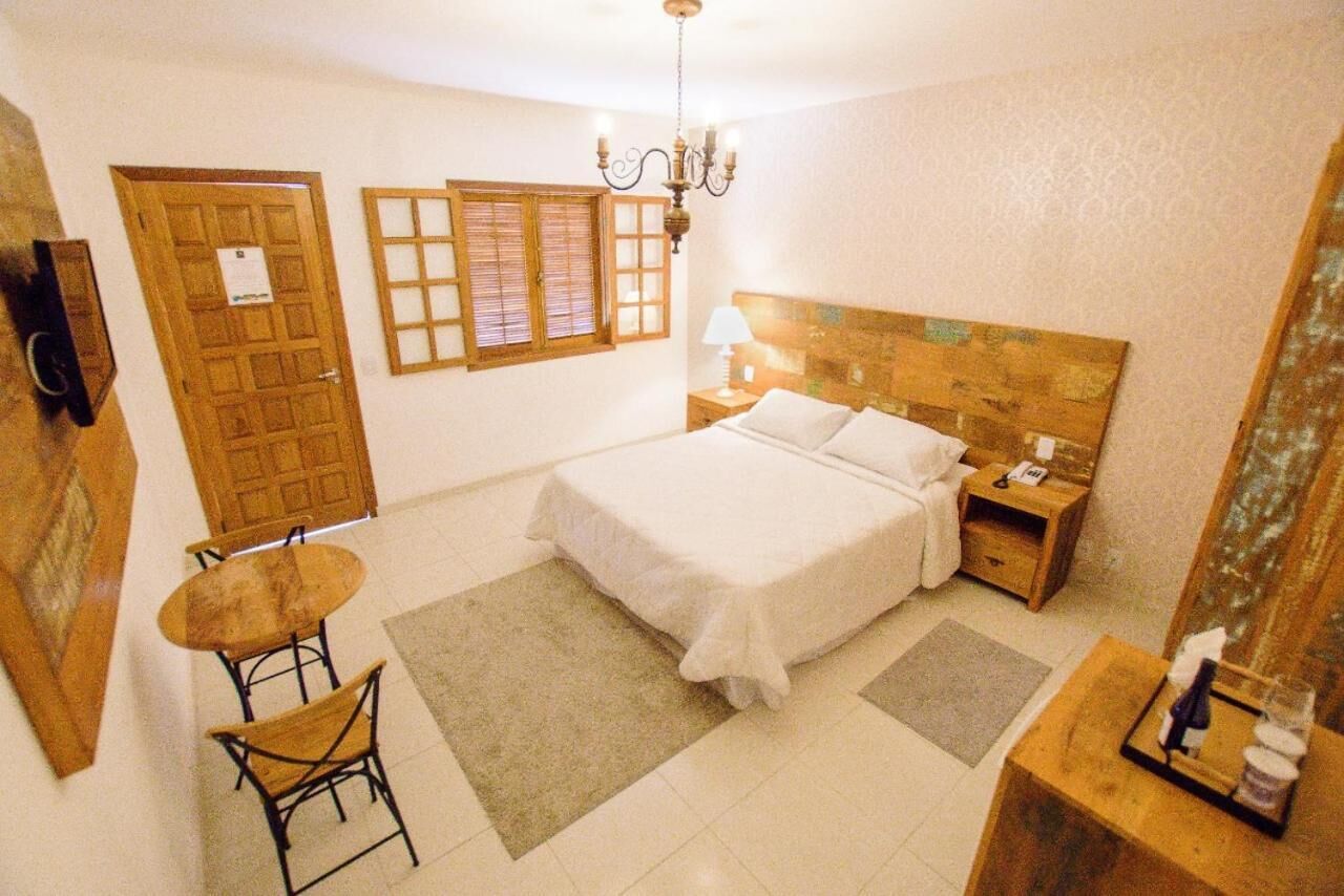 Un dormitorio con una cama, una mesita de noche, una lámpara, una silla y una pequeña mesa.