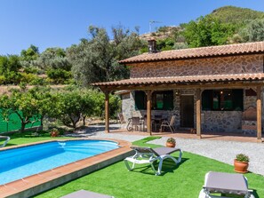 A stone villa with a swimming pool, outdoor seating, and a view of the surrounding hills. - Charming farmhouse among orange trees (Cónchar)