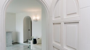 Un pasillo con una puerta, una pared y un piso, todo en color blanco.