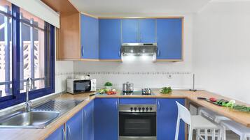 Een koelkast, een koffiezetapparaat/waterkoker, een kinderstoel