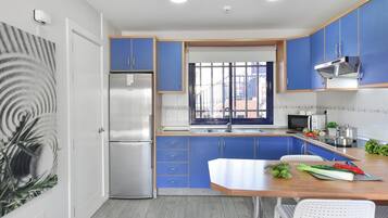 Een koelkast, een koffiezetapparaat/waterkoker, een kinderstoel