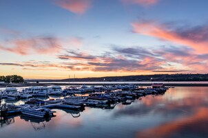 Un puerto deportivo con varias embarcaciones amarradas en aguas tranquilas al atardecer.