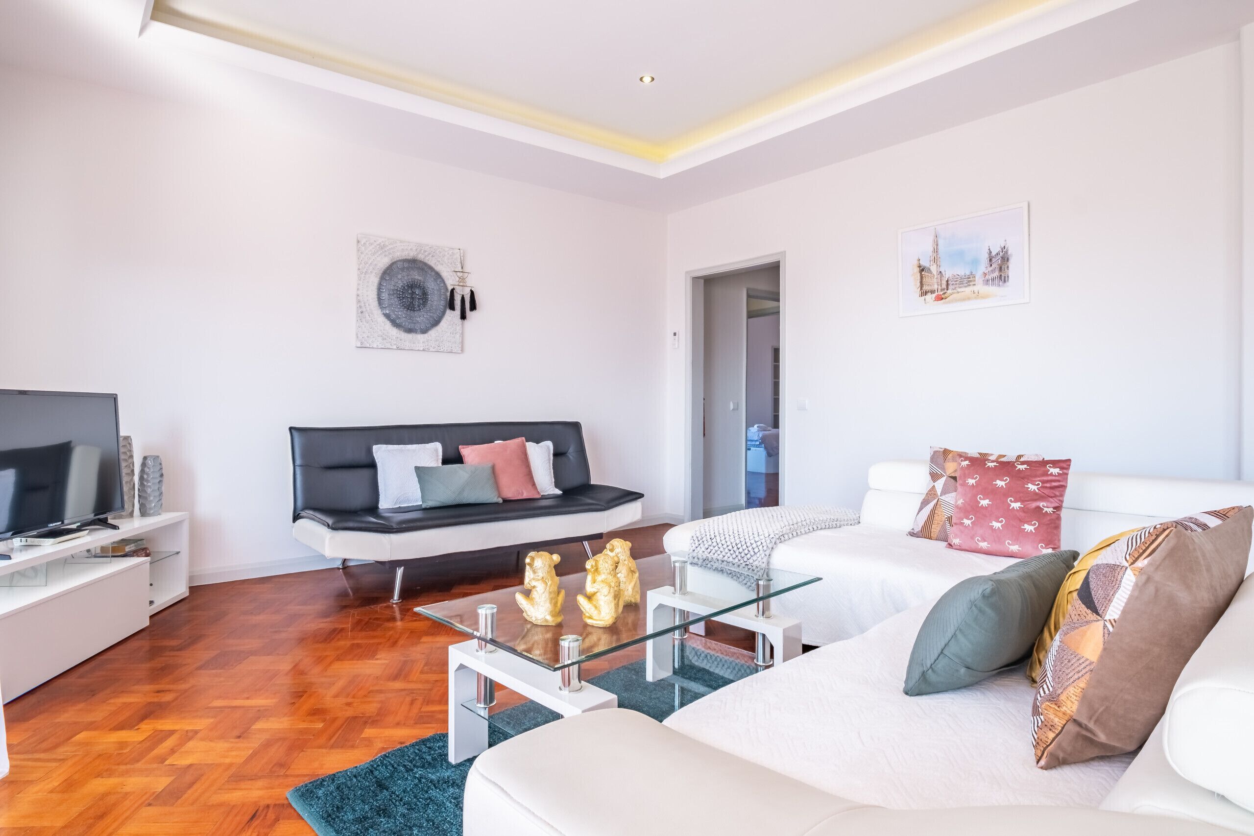 A modern living room with a sofa, a coffee table, and a TV.