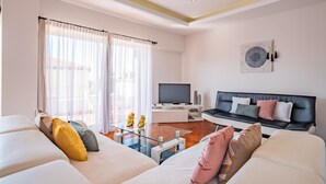 Un salon moderne avec un canapé, une table basse et un téléviseur.