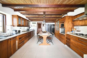 A kitchen with wooden cabinets, a central island, and stainless steel appliances.