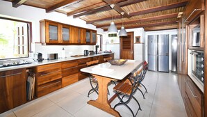 Una cocina moderna con armarios de madera, una isla central y electrodomésticos de acero inoxidable.