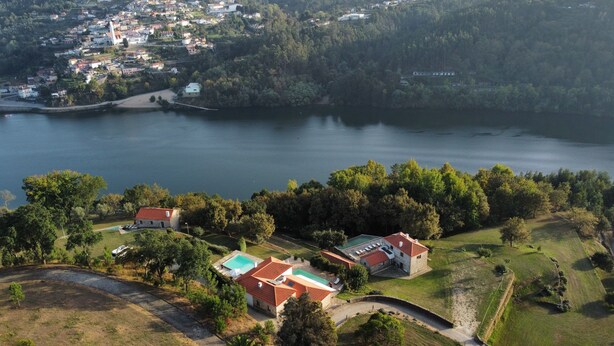 An aerial view of a coastal area with houses, a lake, and a beach.