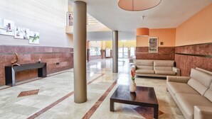 A spacious lobby with a marble floor, a sofa, a coffee table, and a bench. - Luxury apartment in Puerto Rico (Mogán) (Mogán)