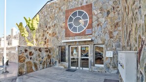 A stone building with a large circular window and a sign reading "RESIDENCIAL EL VALLE". - Luxury apartment in Puerto Rico (Mogán) (Mogán)