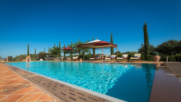 A swimming pool with lounge chairs and umbrellas, surrounded by trees and a clear sky. - Special Offer! Holidays, (Villa Lestra 8 + 3) Area Volterra, San Gimignano, Pisa (Pisa)