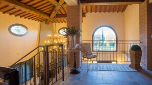 A spacious balcony with a wrought iron railing, a wicker chair, a potted plant, and a view of the outdoors. - Special Offer! Holidays, (Villa Lestra 8 + 3) Area Volterra, San Gimignano, Pisa (Pisa)