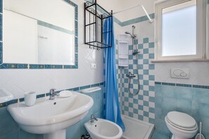 Een douche, een haardroger, een bidet, handdoeken
