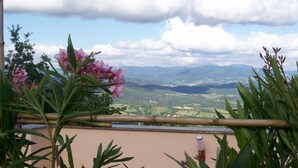 A balcony with a view of a valley, surrounded by greenery and a clear sky. - Horizons on the splendid Val di Cornia scenic two and comfortable  (Monteverdi Marittimo)