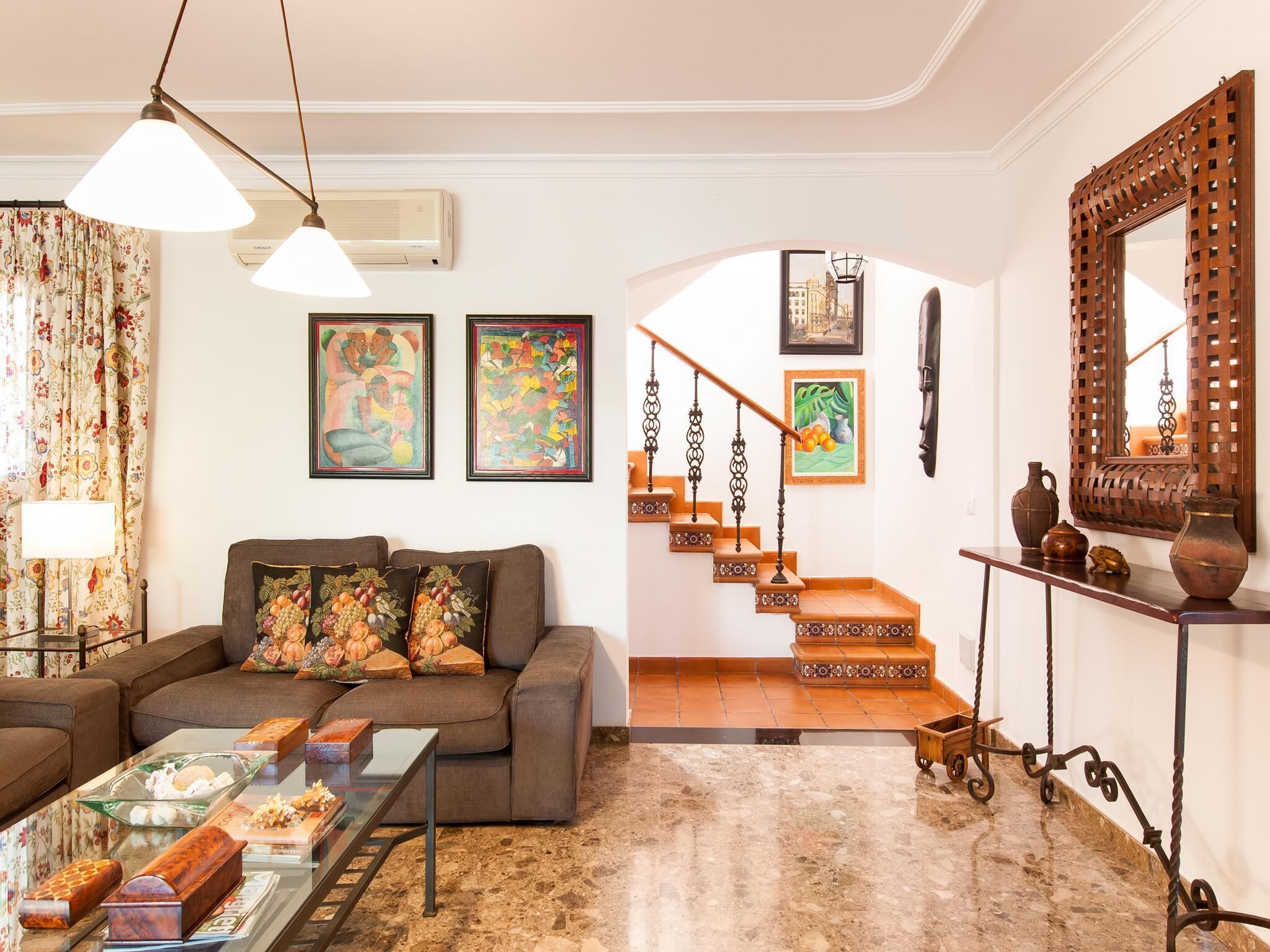 A living room with a sofa, coffee table, and artwork on the walls.