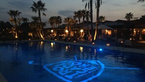 A pool with a blue design at dusk. - A modern penthouse (110 m2) with sea and pool view, 3 bedrooms and 2 baths (Alcaidesa, San Roque, Sotogrande)