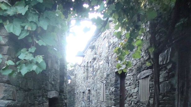 A narrow stone pathway flanked by old stone buildings with steps leading up to a door. - Artur apartment with balcony (Lousã)