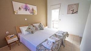 Ein Schlafzimmer mit einem großen Bett, zwei Kissen, einem Nachttisch mit Büchern und einem Fenster mit Blick.