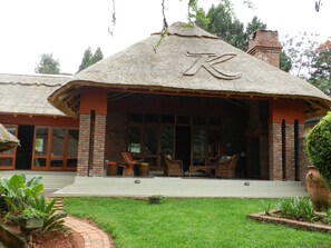 A building with a thatched roof and a large letter 'K' on the front. - Kutandara Lodges (Harare)