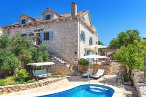 A stone villa with a swimming pool, outdoor seating, and a staircase leading to the upper floors. - Traditional Villa Vicina with Private Pool in Milna, Brac Island (Milna)
