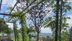 Uma área de estar externa com móveis de vime e vista para a paisagem.