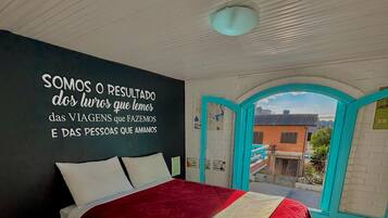 Un dormitorio con cama, una pared con una cita motivacional y vista a través de una puerta abierta.