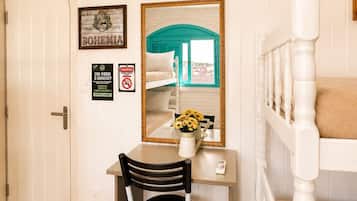 A room with a desk, chair, bunk bed, and a door.