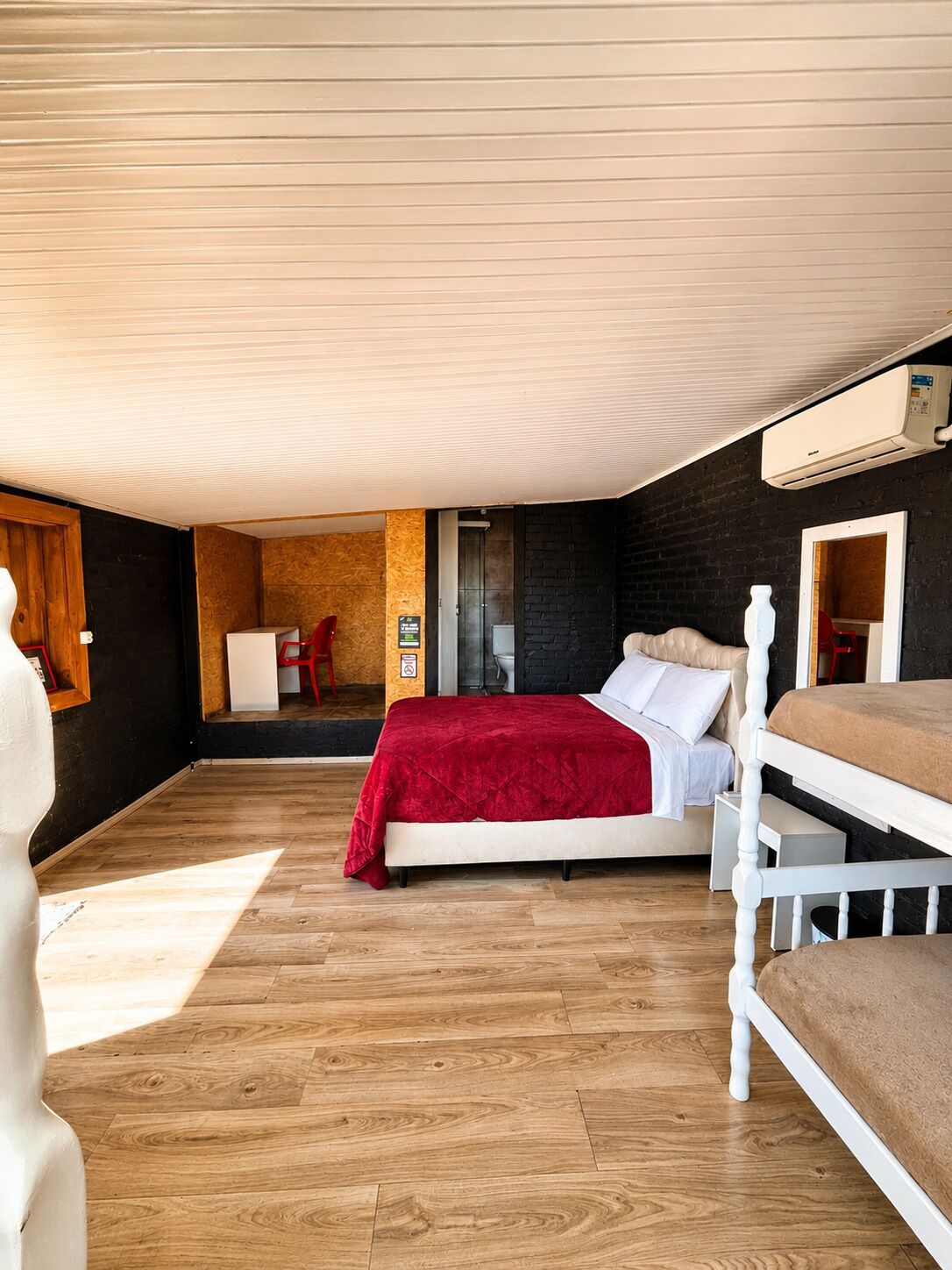 A compact room with a bed, a small seating area, and a visible bathroom.