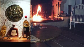 Une pièce avec une cheminée, une bouteille d’alcool et une assiette décorative.