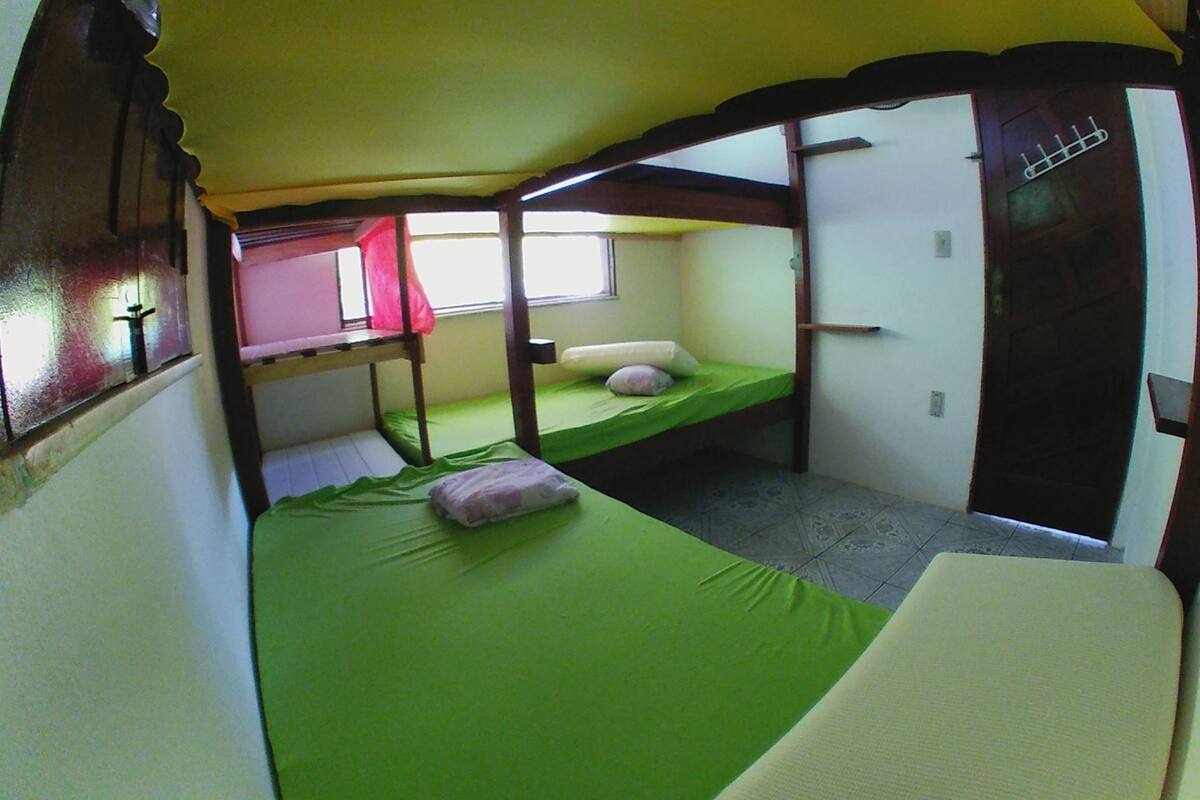 Habitación con literas, ventana, puerta y toma de corriente.