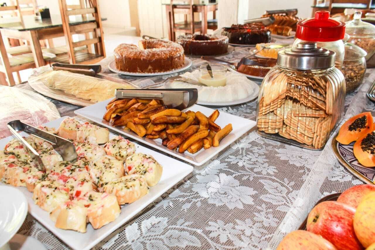A buffet table with various dishes including cakes, pastries, and fruits.