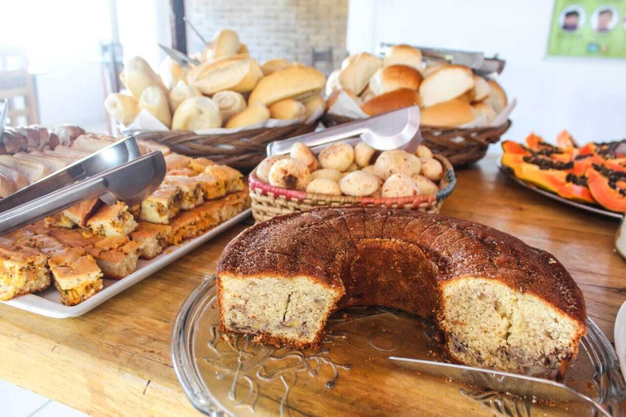 Un buffet proposant une variété de produits de boulangerie, notamment du pain, des petits pains et un grand gâteau.