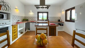 Una cocina compacta con una isla central, un microondas y un lavavajillas.
