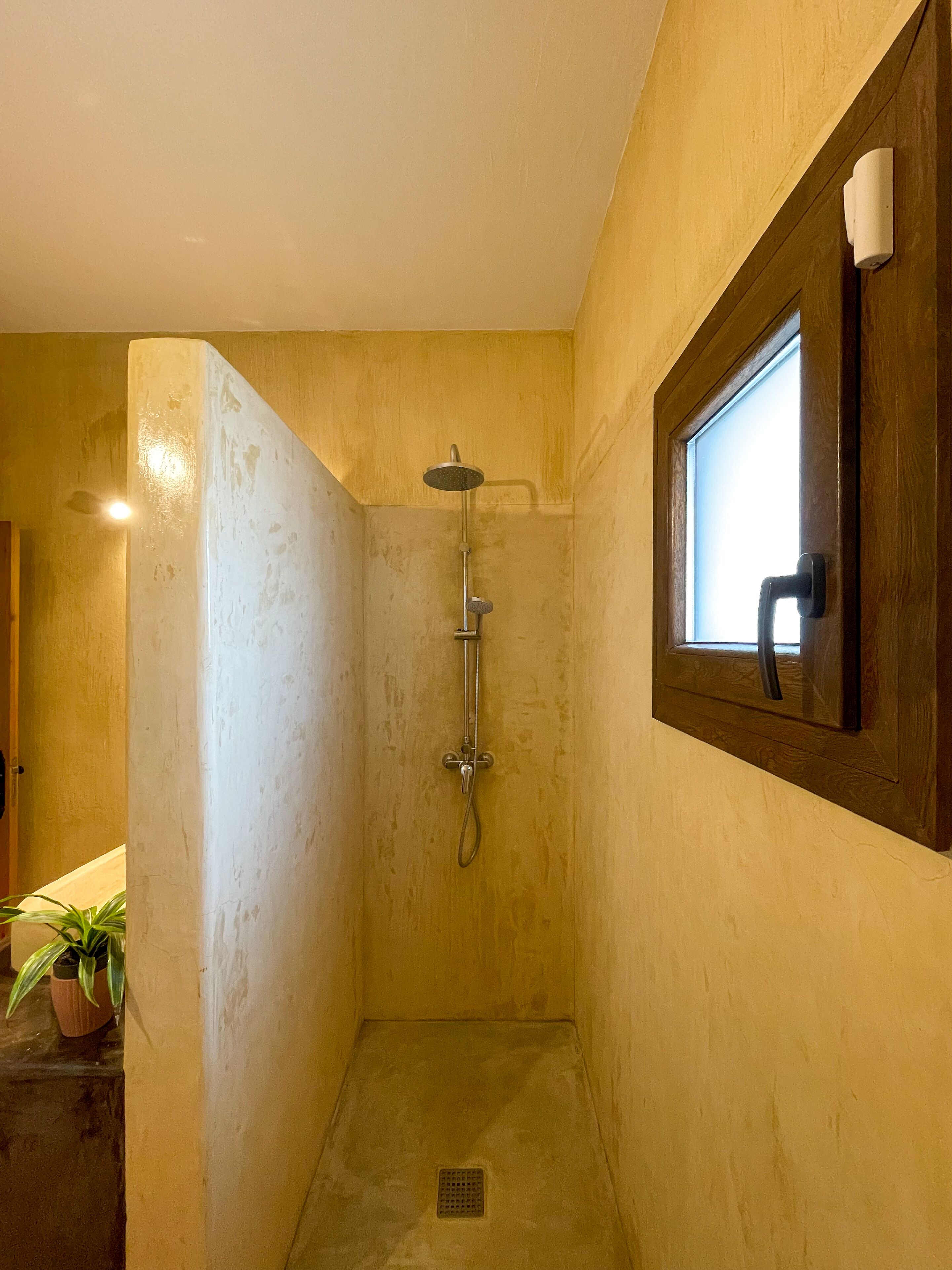 Un baño pequeño y estrecho con puerta de madera y ventana.