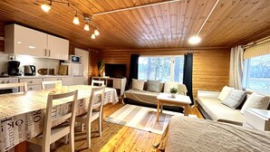 A cozy cabin-style room with a dining area, a sofa, and a TV. - Köningsviken vacations in Sipoo (Sibbo)