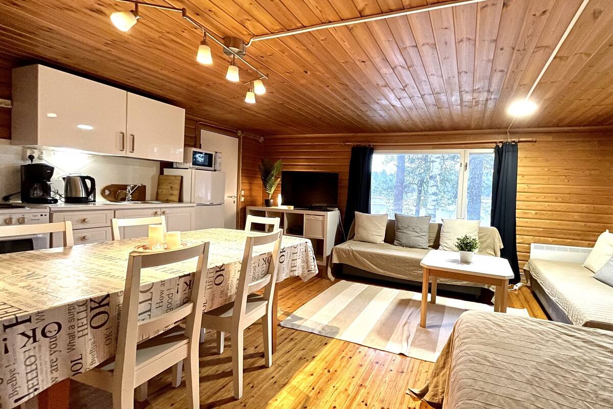 Um quarto acolhedor estilo cabana, com área de jantar, sofá e televisão.