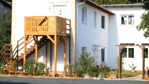 Un edificio a due piani con una veranda in legno e un portico coperto.