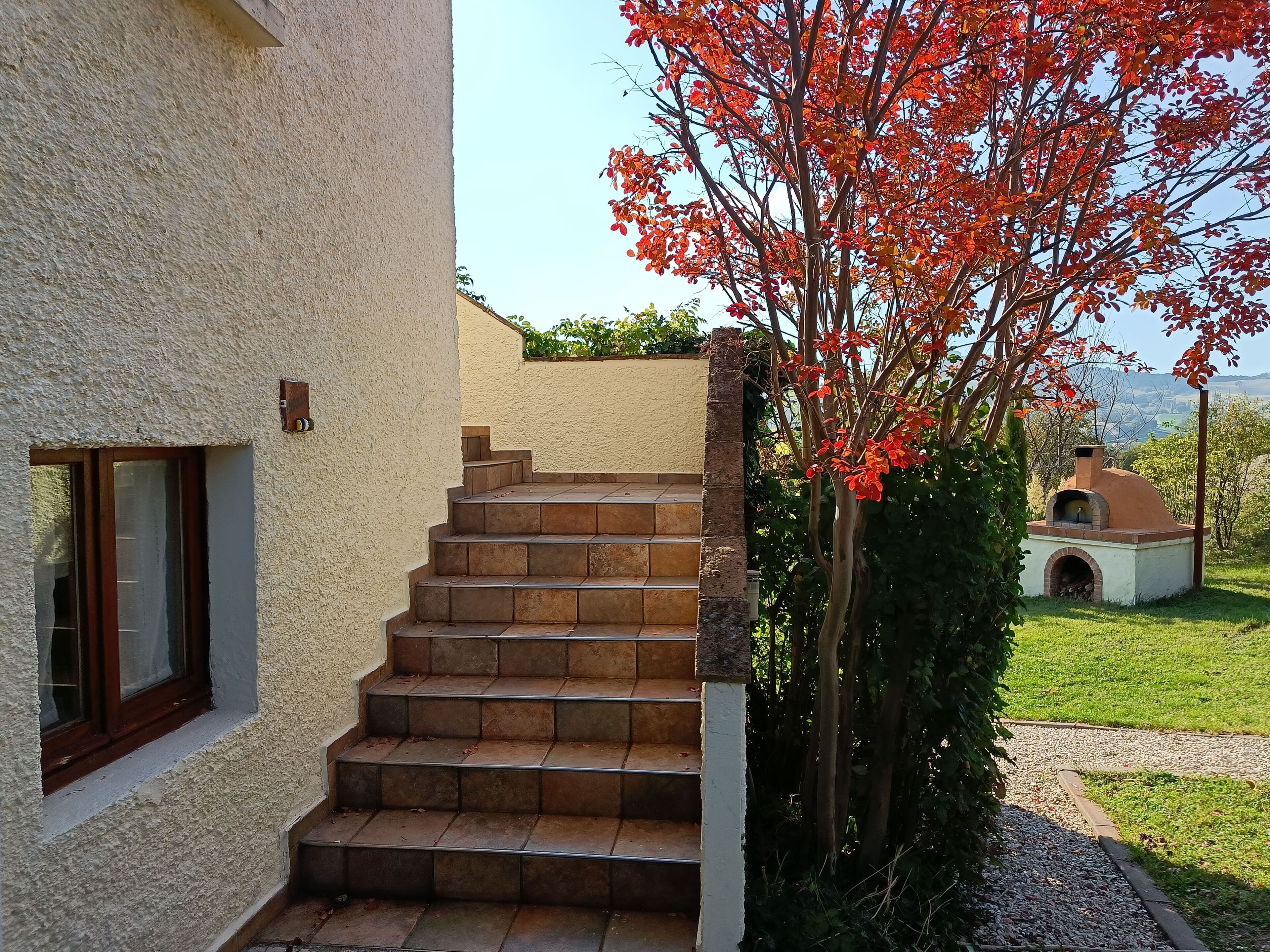 A set of stone steps leading to a white building with a window.