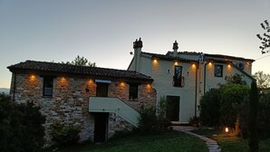Un bâtiment en pierre, doté d’un toit recouvert de tuiles et d’un petit escalier menant à une porte.