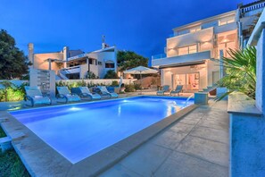 A modern pool area with lounge chairs and a clear blue pool.