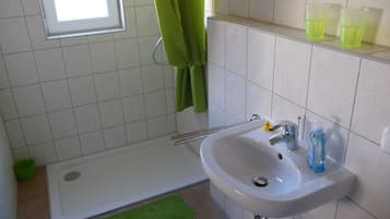 Een badkamer met een bad, een wastafel en een raam.