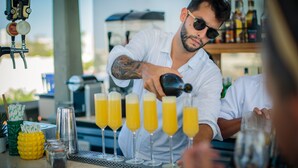 Een barman schenkt drankjes in glazen aan de bar.