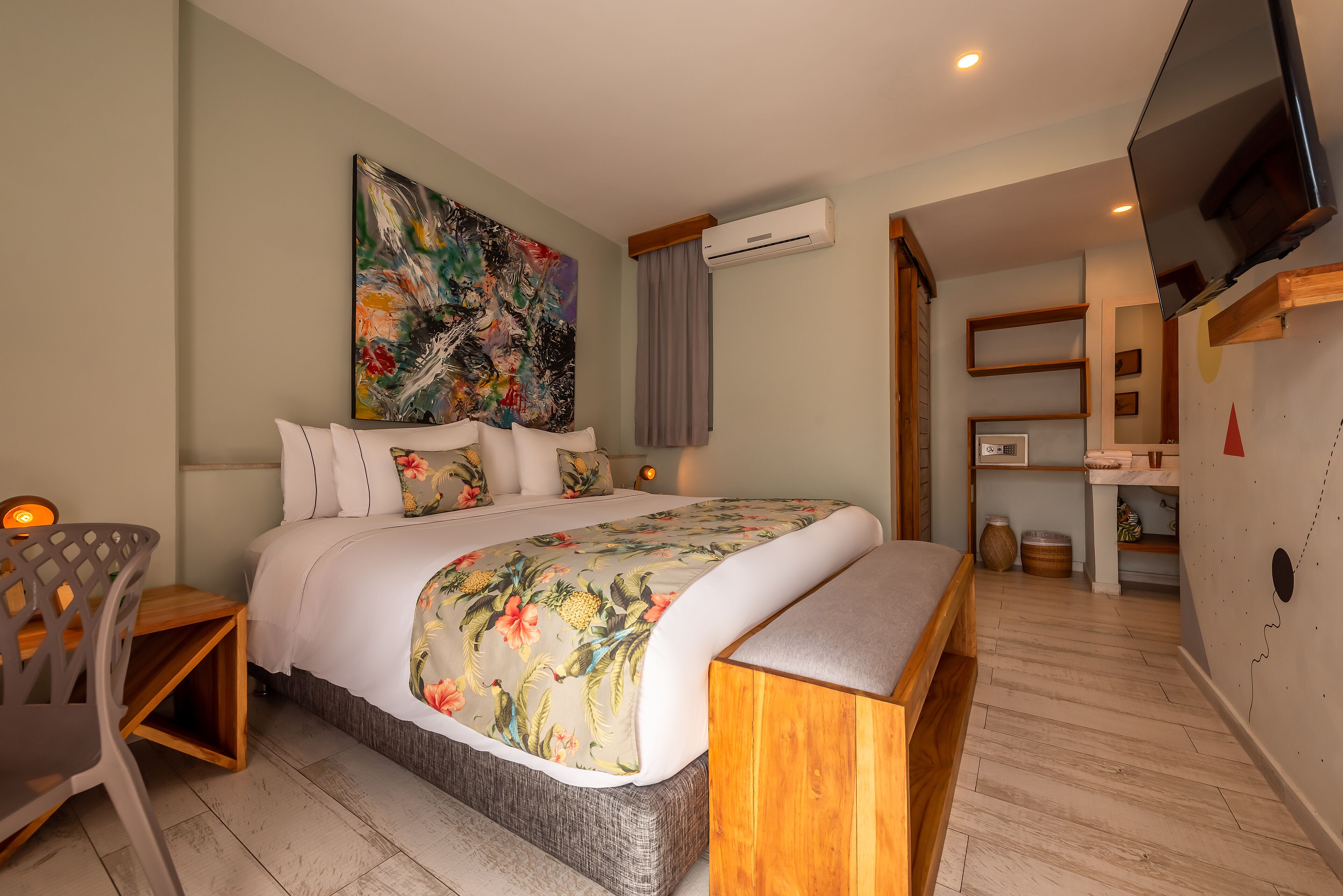 A modern bedroom with a large bed, a wooden headboard, a flat-screen TV, and a painting on the wall.