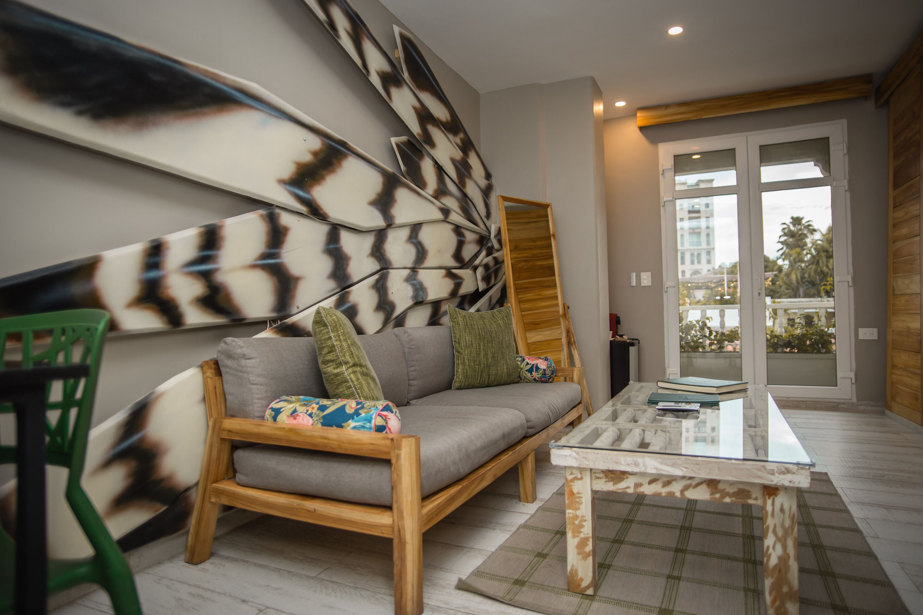 A modern living room with a grey sofa, wooden coffee table, and a large abstract wall art piece.