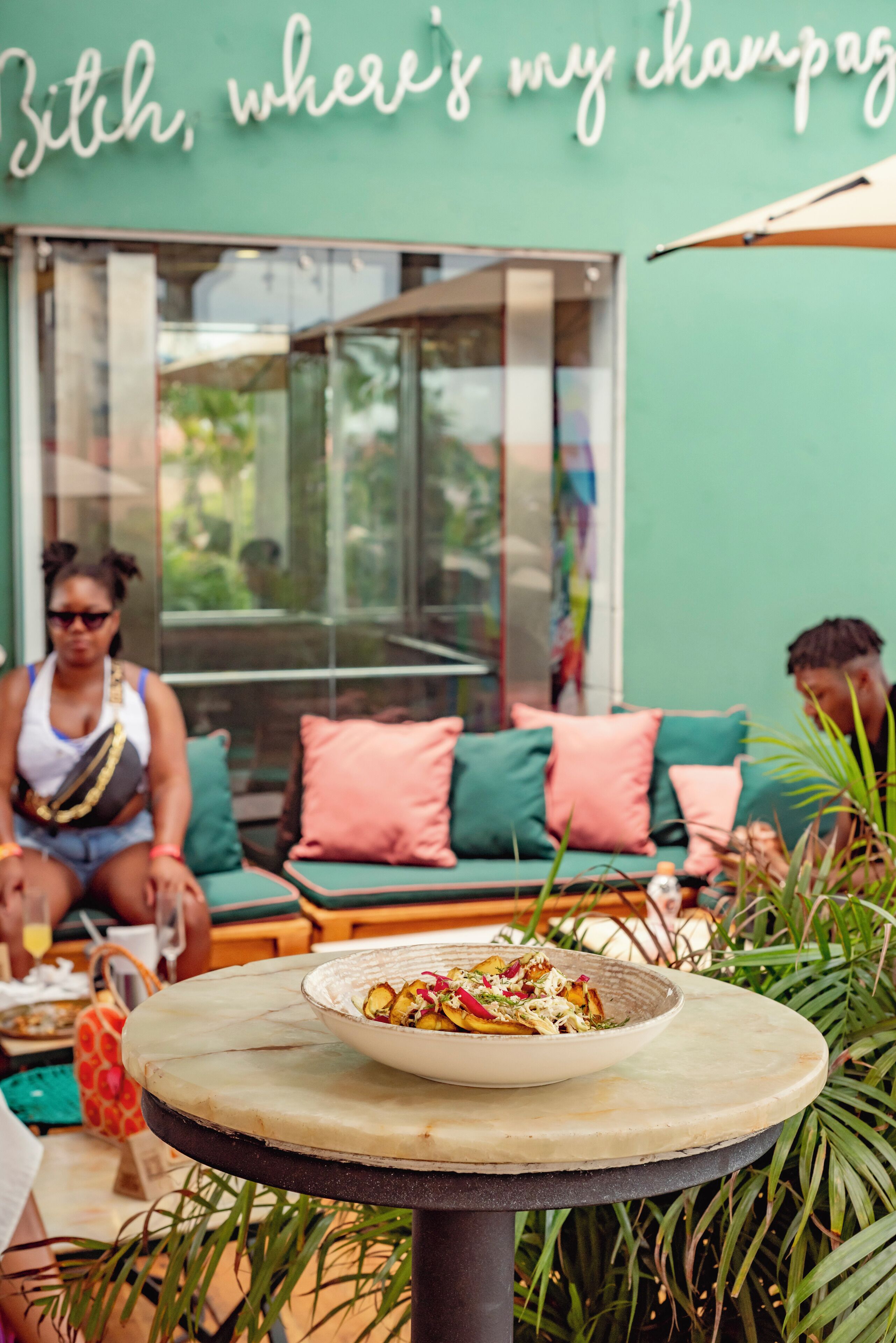 Een terras met een tafel, stoelen en een schaal eten.
