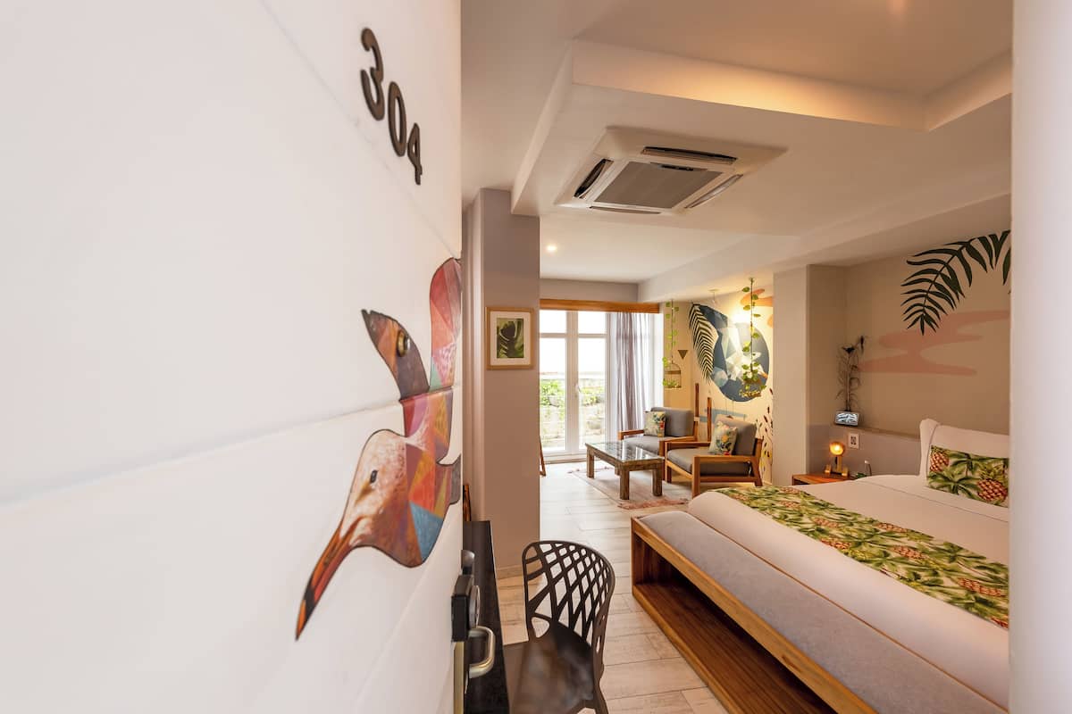 Une chambre d’hôtel moderne avec un grand lit, un canapé et un coin repas.