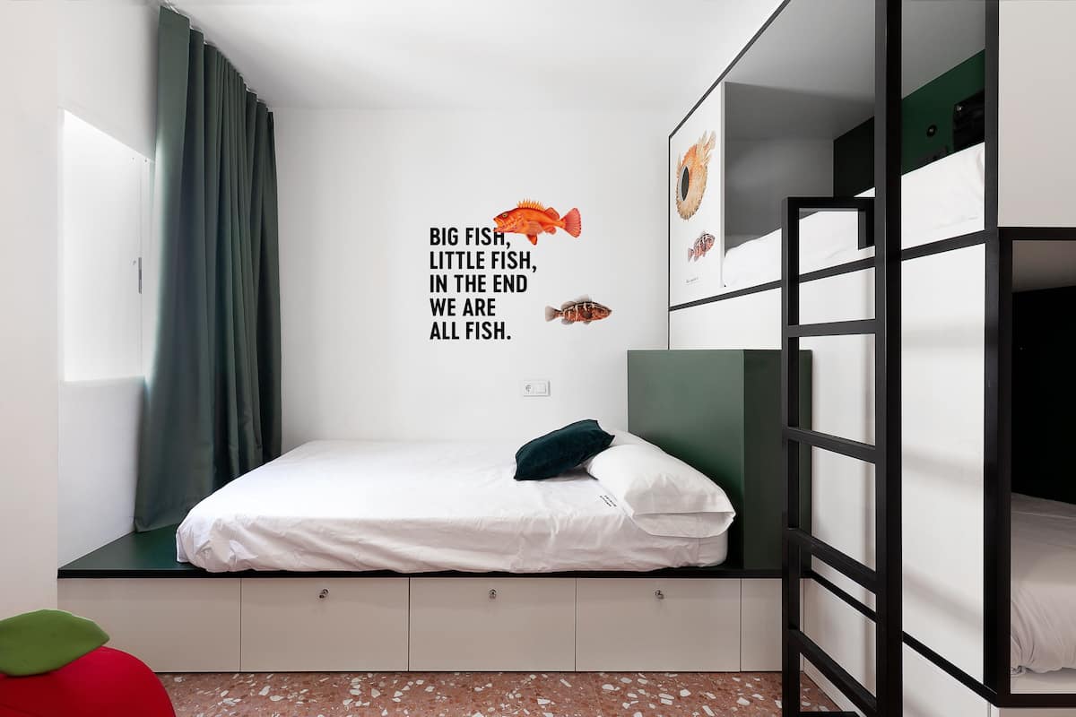 A bunk bed room with a wall decal featuring fish and a quote.