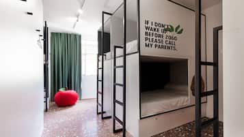 Una habitación moderna con una cama litera, un sillón de peluche rojo y una pared con un mensaje divertido.