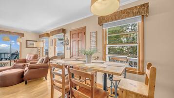 Un salon spacieux avec une table à manger en bois, des canapés en cuir et une grande fenêtre offrant une belle vue.
